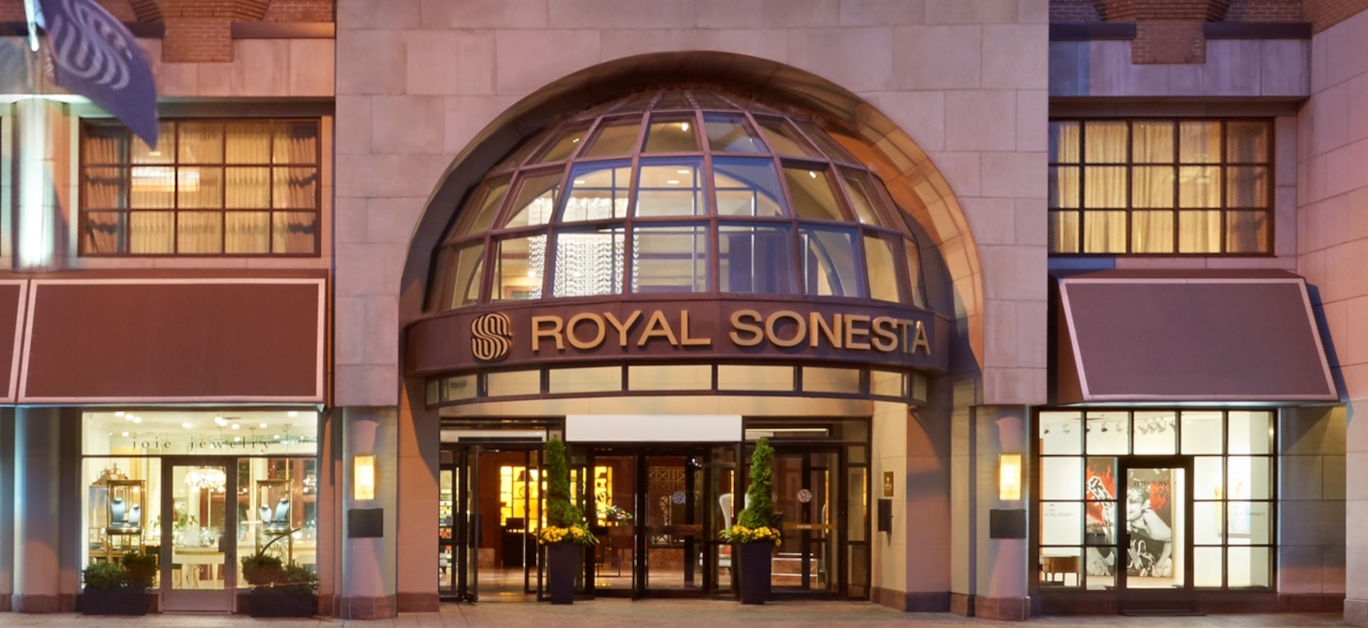 ROYAL SONESTA displayed in capital letters above the entrance of a building with a large arched window.