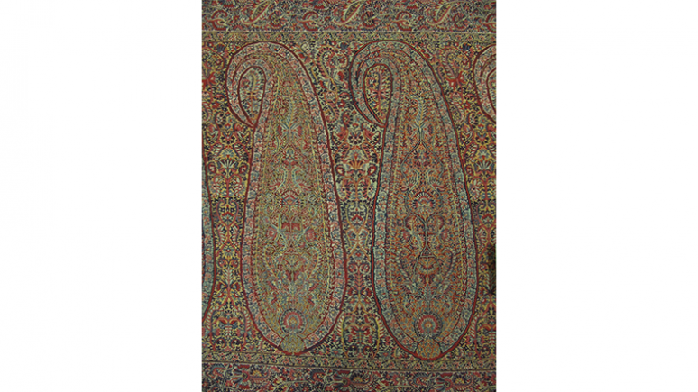 Intricate rectangular textile with ornate paisley and floral patterns in muted earth tones.