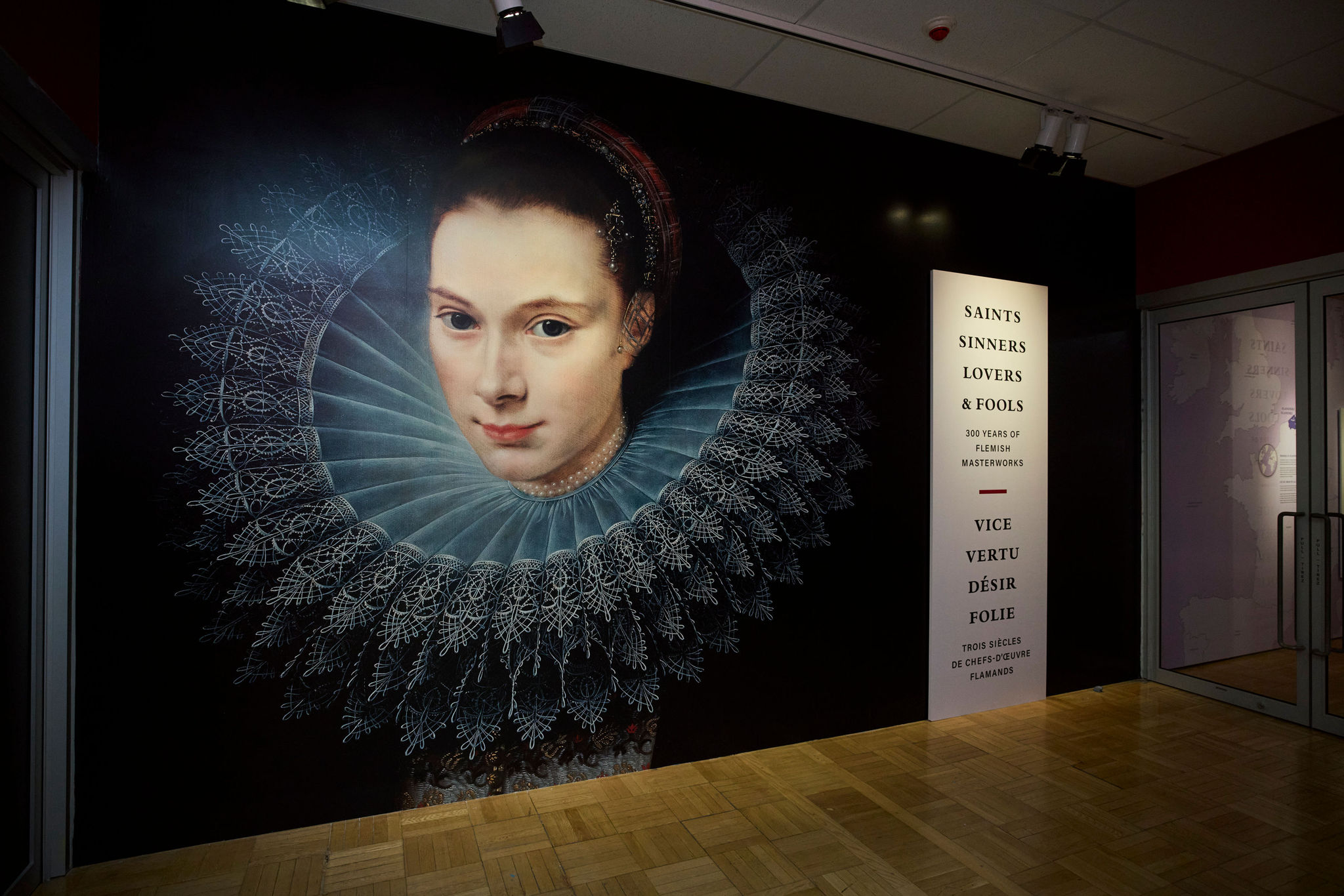Mural of a woman with a lace ruff collar next to a vertical text panel listing names and dates.