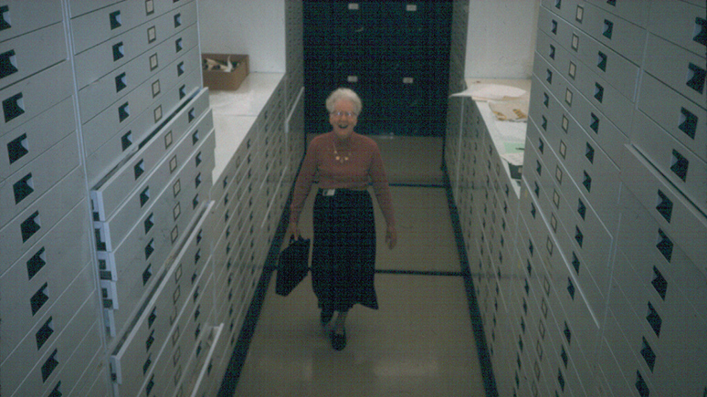 Photo of Dorothy Burnham standing in the textiles storage area.
