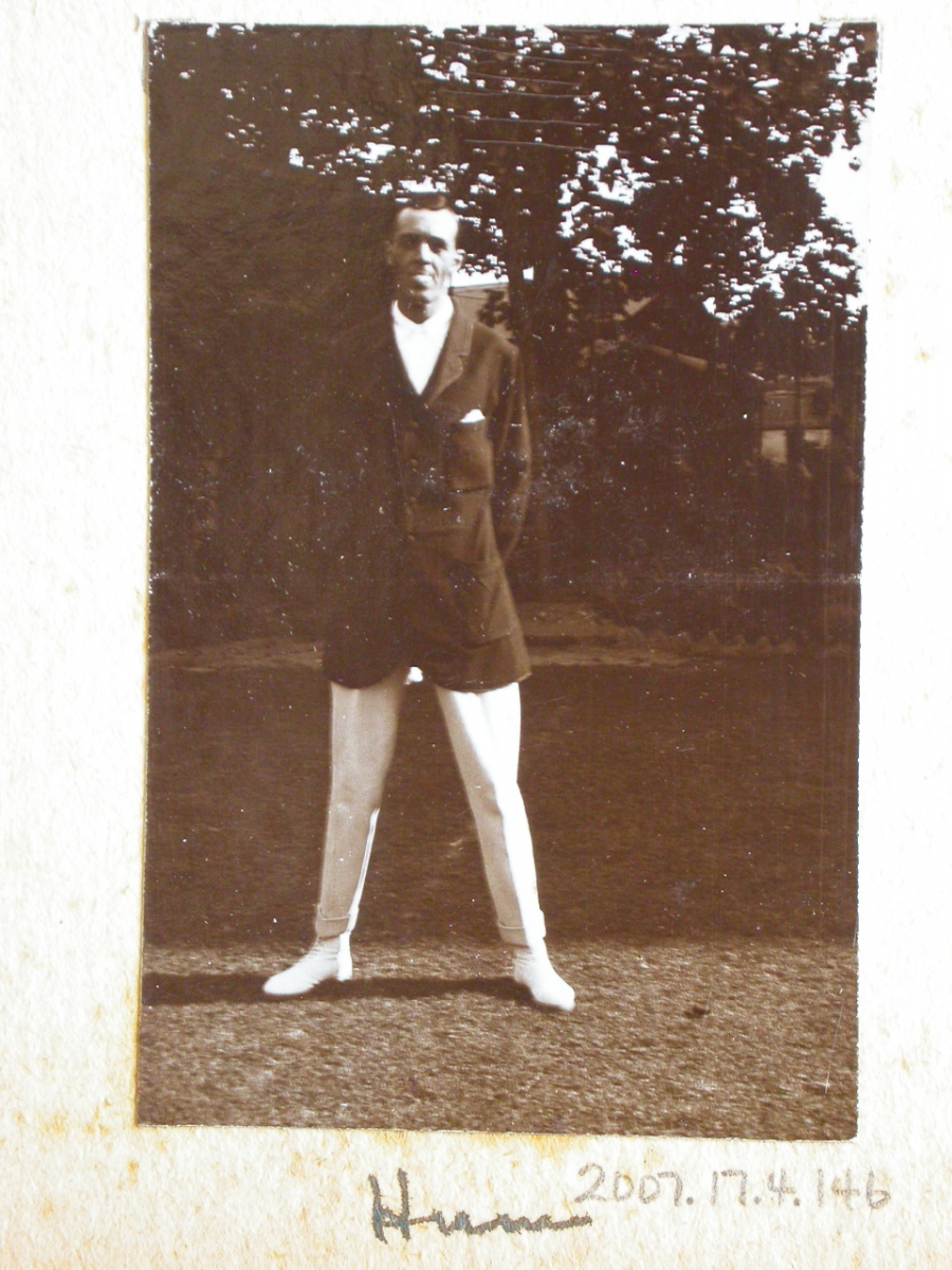 No visible text; black-and-white photo of a woman standing outdoors wearing a dark coat and white boots.