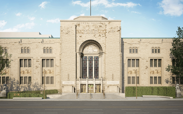 Front view of a large beige stone building with a tall central arched window and symmetrical wings.