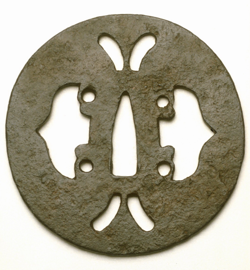 Tsuba ronde en fer avec un motif symétrique découpé présentant des papillons et des formes florales.