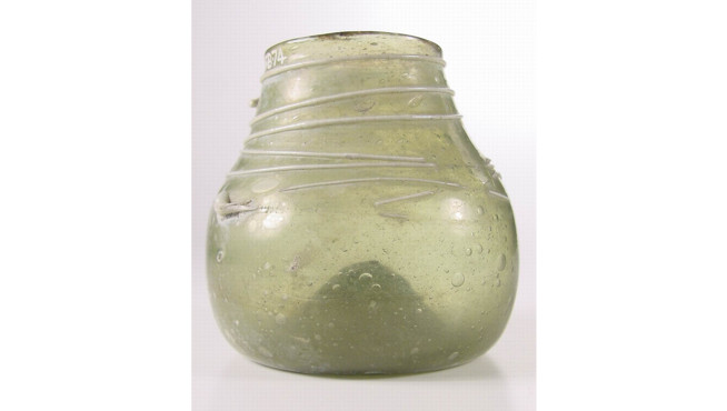 Rounded translucent green glass vessel with a wide body and narrower neck, wrapped with thin wire coils near the top.