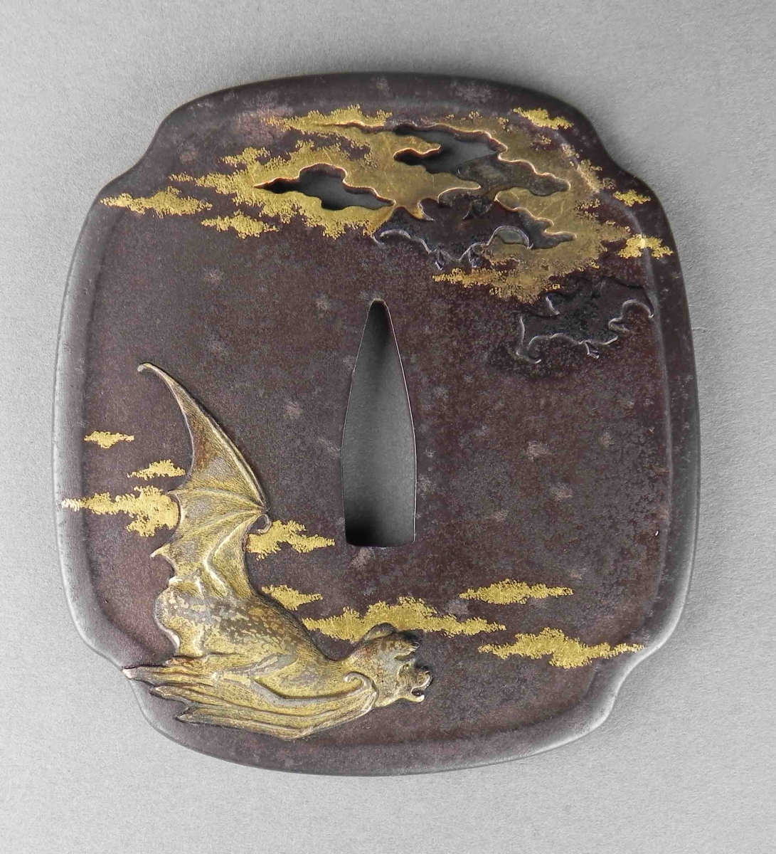 Garde d'épée tsuba en fer avec incrustation d'or représentant un personnage assis et des nuages.