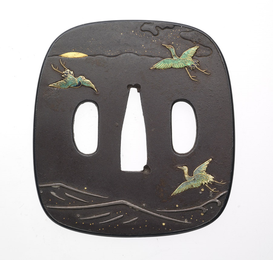 Tsuba noire carrée avec des oiseaux peints en or et en vert et un motif de lignes ondulées sur le bord inférieur.