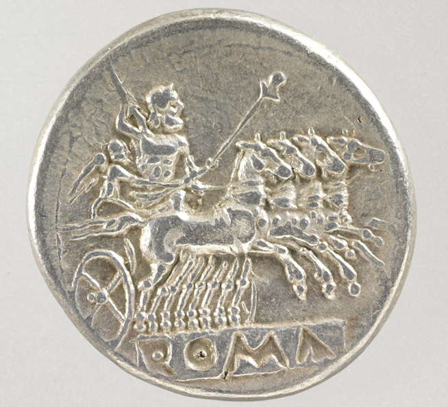 Ancient silver coin depicting a four-horse chariot and a charioteer holding a whip, with Greek letters below.