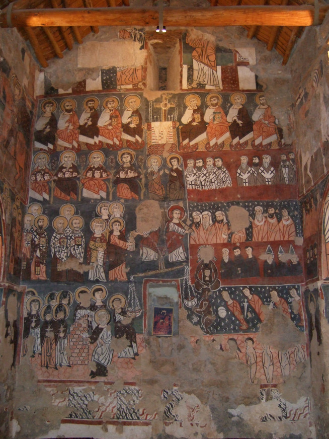 Fresco mural depicting multiple religious figures arranged in rows within an arched, stone-walled interior.