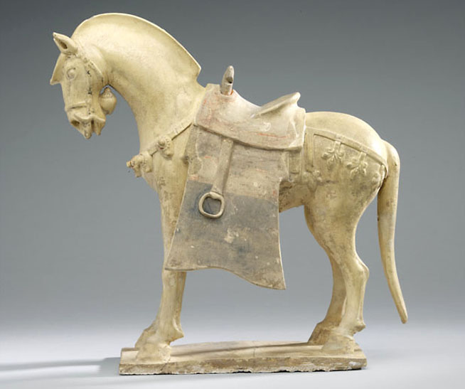 Tang dynasty ceramic horse statue with saddle and decorative harness.