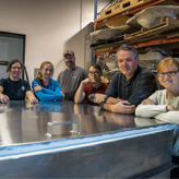 ROM's Blue Whale team pose beside the shipping container holding the blue whale heart.
