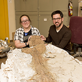 Photo of two people with a fossil
