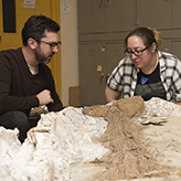 Photo of two peope with a fossil
