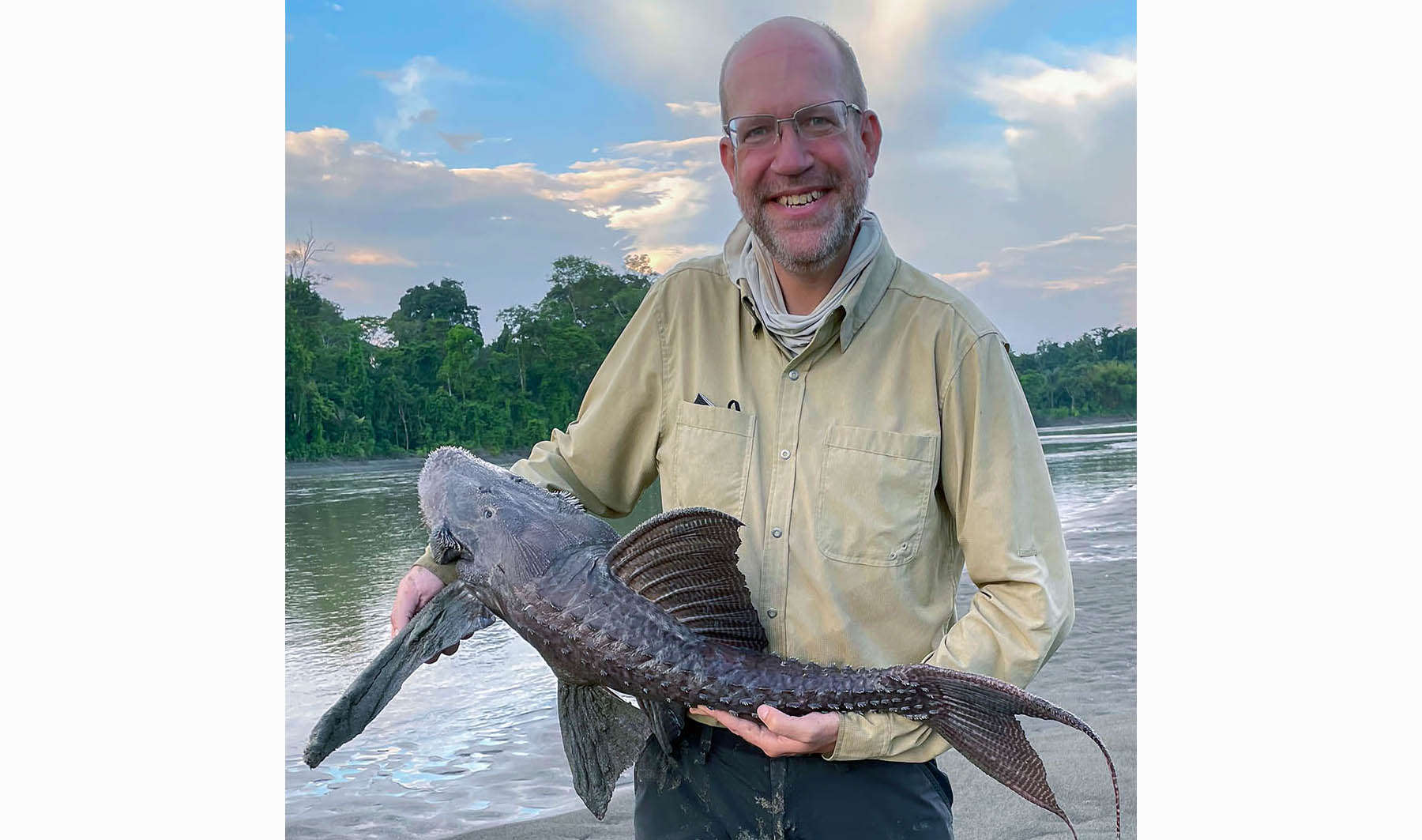 A man holding up a suckermouth armored catfish.