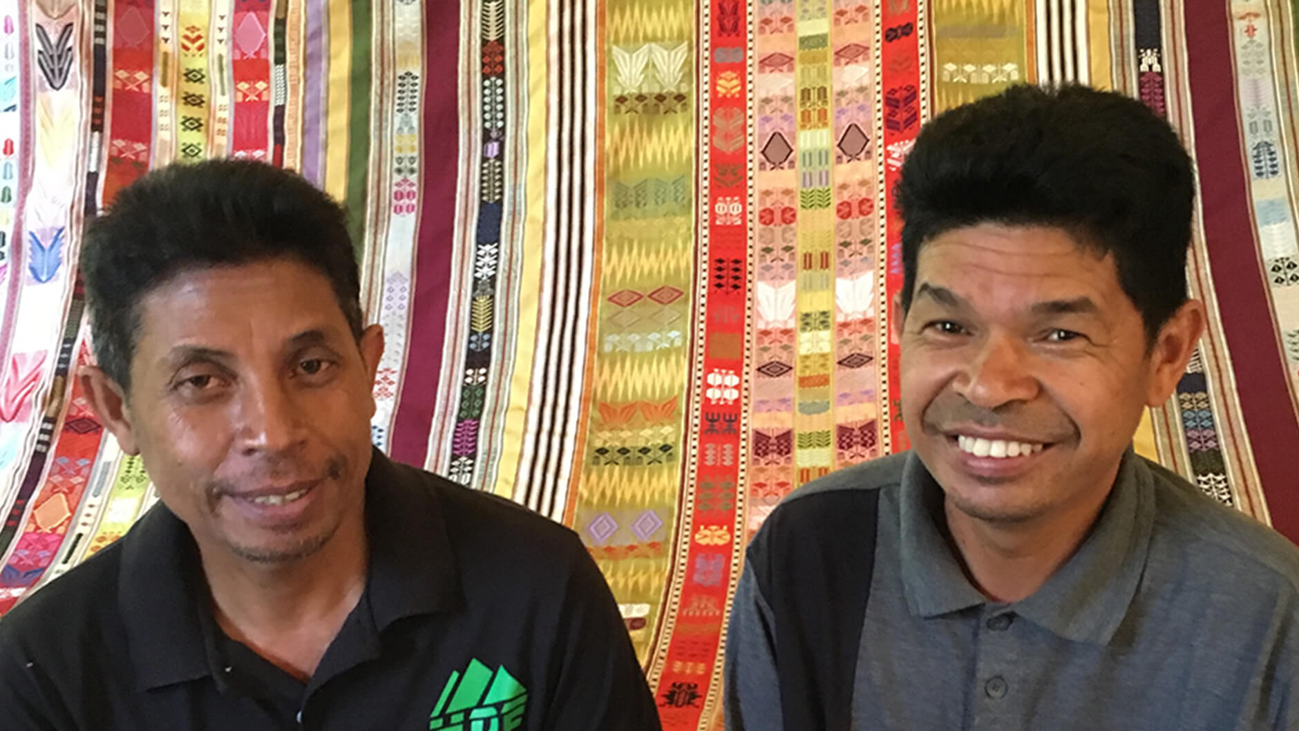 Martin Rakotoarimanana avec Daniel Rafidison, devant un textile coloré.