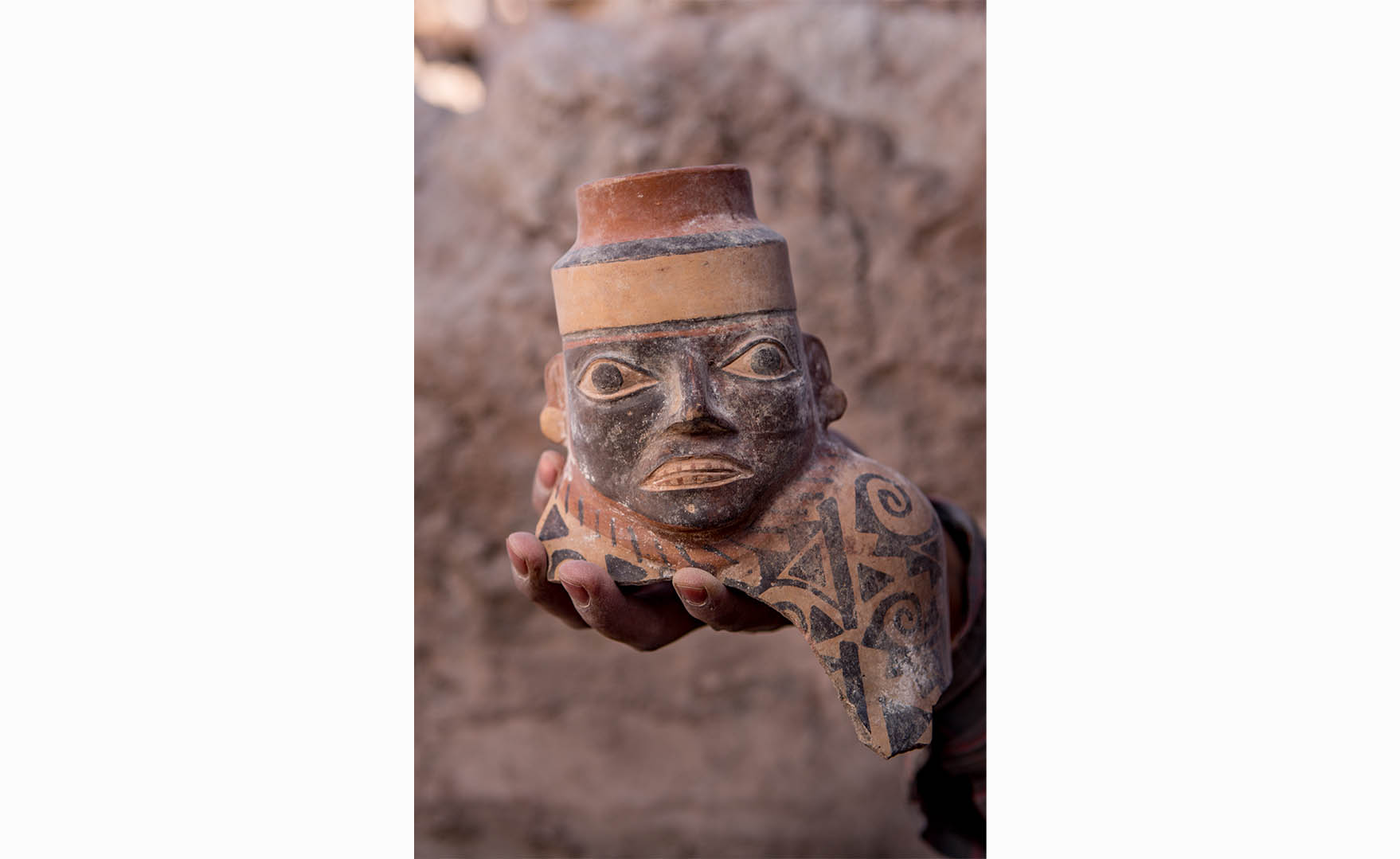 Gros plan d'une jarre à col facial. Plus de 800 ans avant les Incas, l'État Wari s'est étendu hors de la Sierra centrale péruvienne vers 600 après J.-C. et a façonné les interactions dans la région pendant les quatre cents années suivantes. Les céramiques Wari, comme cette jarre à col facial de Robles Moqo découverte à Quilcapampa, se retrouvent dans une grande partie du Pérou.