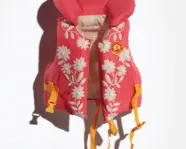 Red life jacket with white floral designs and yellow straps.