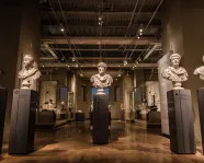 Gallery with seven marble busts of men arranged on tall pedestals in two rows inside the Royal Ontario Museum.