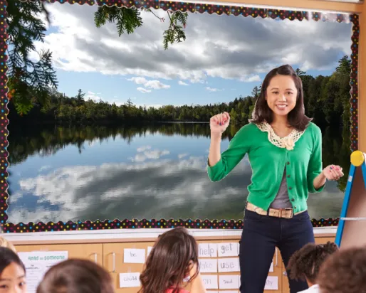Un enseignant vêtu d'un gilet vert se tient devant un tableau intelligent à l'entrée d'une classe. Le tableau affiche l'image d'un lac vitreux.