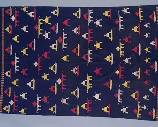 Woven textile with dark blue background and geometric patterns in red, yellow, white, and blue with fringed edges.