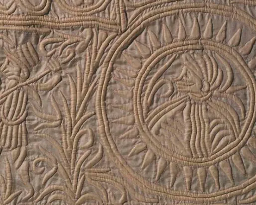 Intricate leaf and flower patterns carved in circular and curved designs on a textured stone surface.