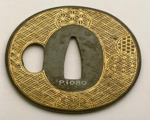 Garde de sabre japonais circulaire avec des motifs géométriques complexes en or et en noir et une découpe centrale.