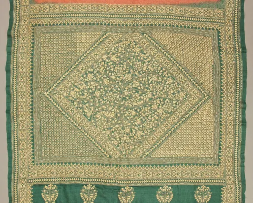 Textile carré avec des bordures vertes et des motifs floraux complexes à l'intérieur d'un losange au centre.