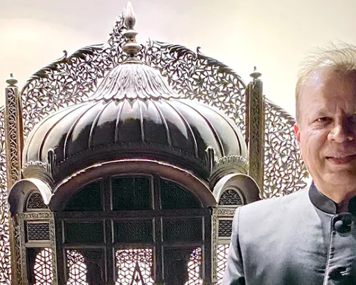 An ornate silver ceremonial object with intricate patterns beside a man in a dark jacket.