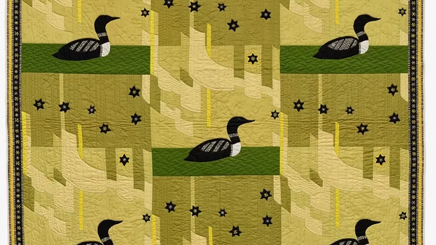A quilt featuring a duck design set against a vibrant green background, showcasing intricate stitching and colorful patterns.