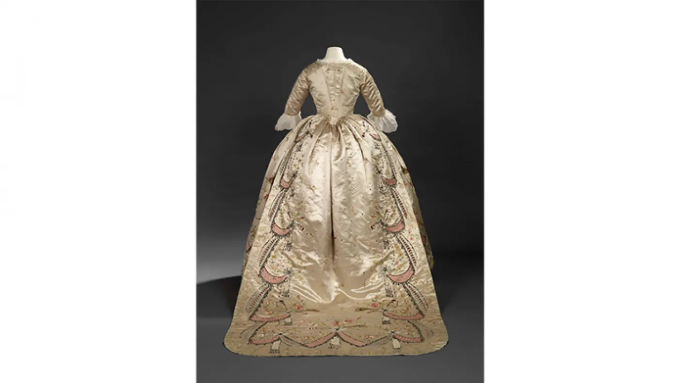 Overdress of a robe en fourreau. Attributed to Marie-Jean "Rose" Bertin (French couturière, 1747-1813). France. 1780's, altered in 1870's. Embroidered satin with ribbon appliqués, sequins, faceted glass stones mounted on silver facings, and silver filé; fitted, boned bodice. 925.18.3.A.