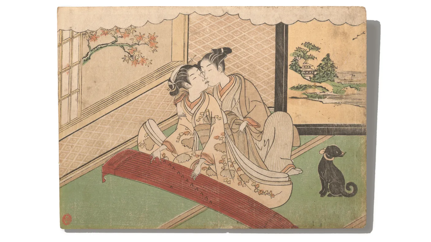 Two women in traditional Japanese clothing seated indoors on tatami mats, one playing a koto instrument, with a black cat nearby and a painted screen of a landscape behind.