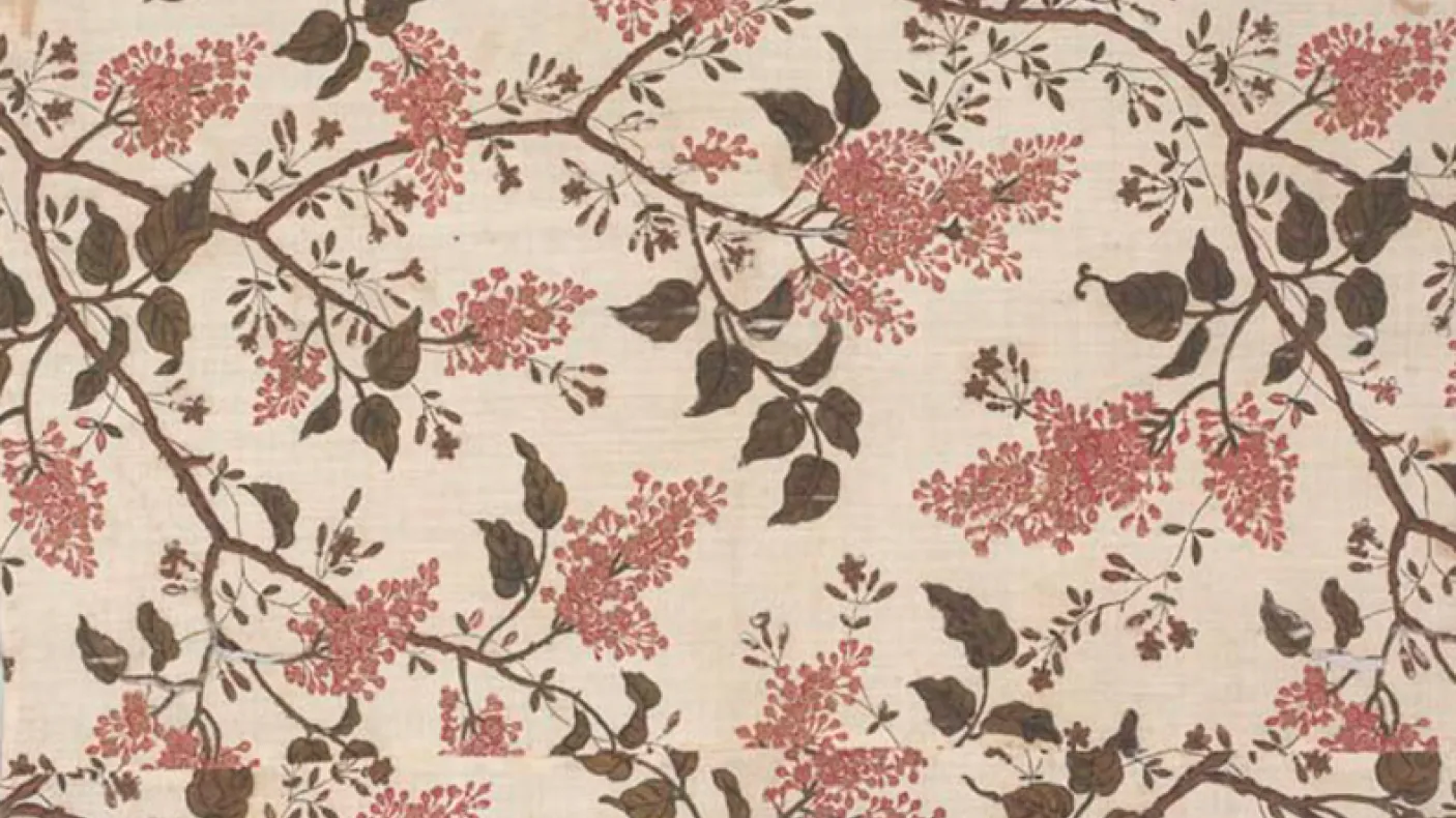 Floral fabric pattern with brown branches and leaves, and pink flower clusters on a beige background.