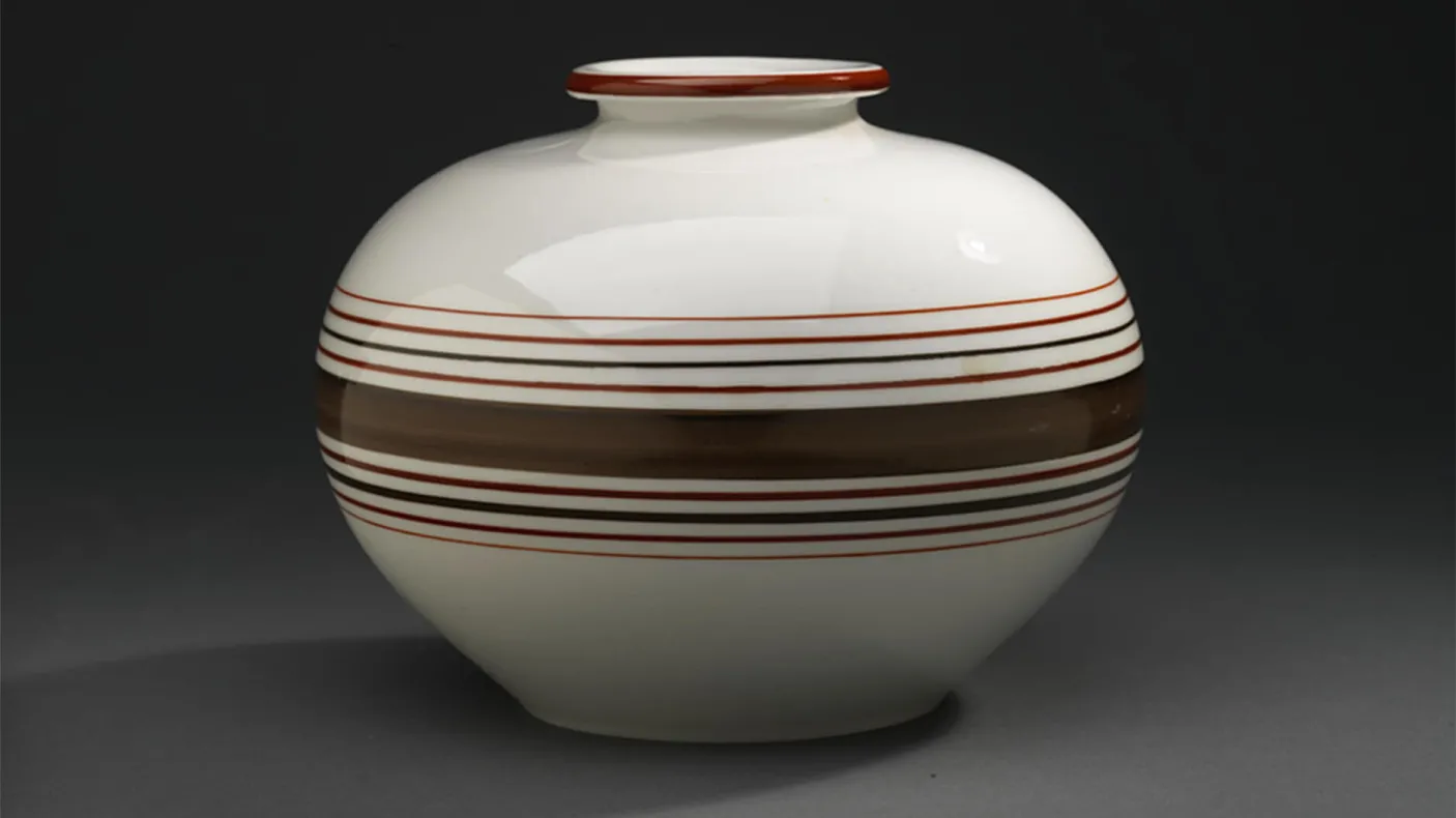 Un vase en porcelaine avec des rayures brunes.