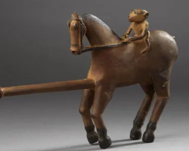 Bronze figurine of a horse with a rider, featuring an extended cylindrical element from the horse's front.
