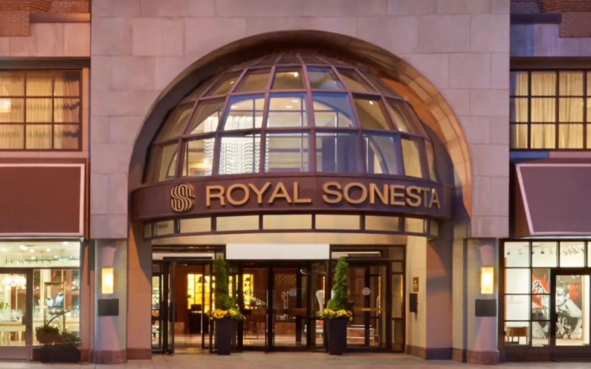 ROYAL SONESTA displayed in capital letters above the entrance of a building with a large arched window.