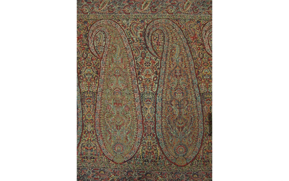 Intricate rectangular textile with ornate paisley and floral patterns in muted earth tones.
