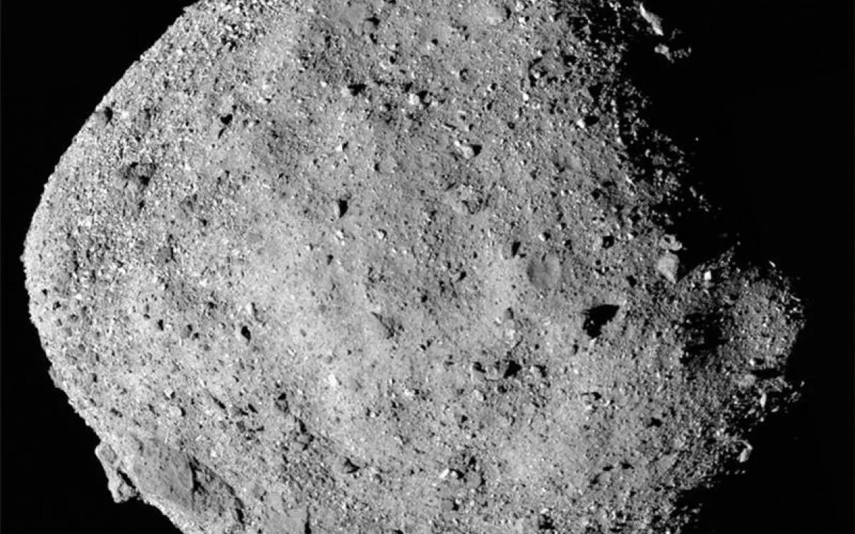Asteroid Bennu, a near-Earth carbonaceous asteroid with a rough, cratered surface, against a black background.