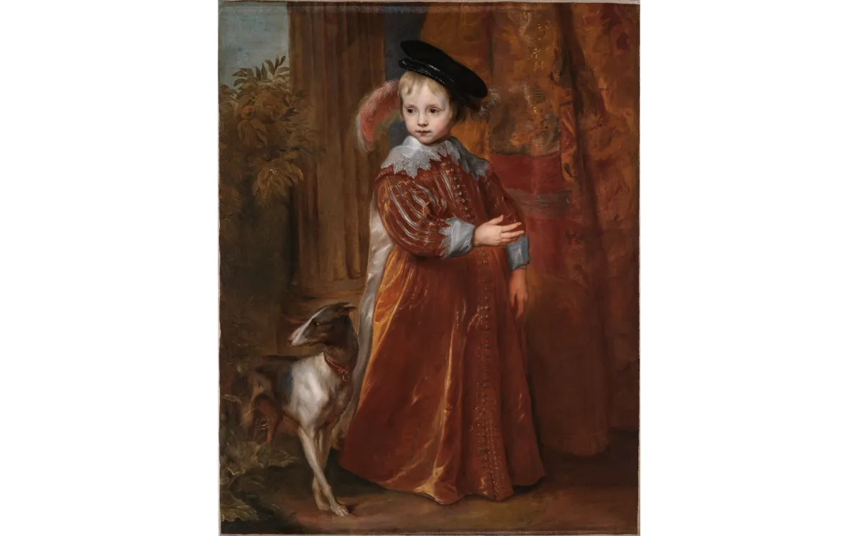 A young girl dressed in a long brown velvet dress with lace at the cuffs and collar, standing beside a dog.
