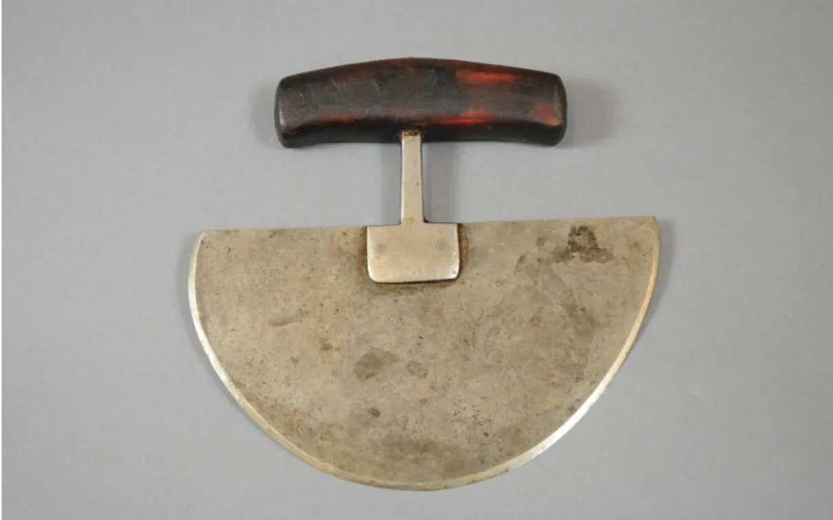 Couteau dont la lame métallique en forme de demi-cercle est reliée à un manche en bois.