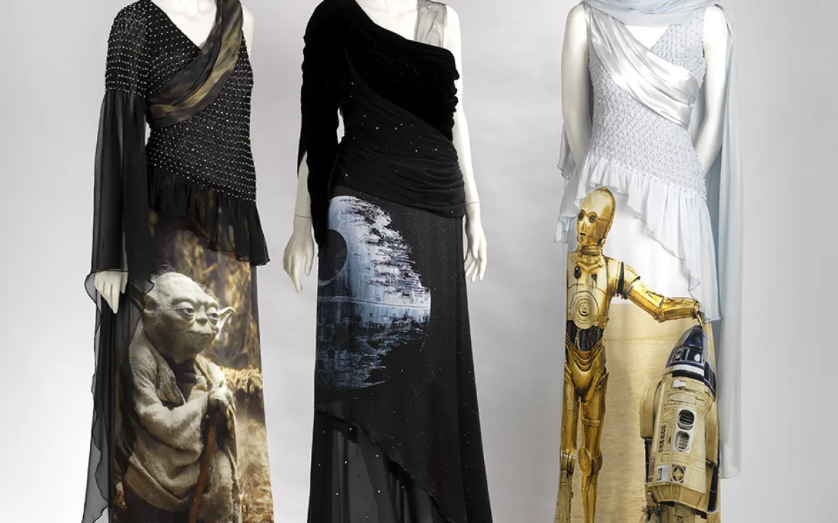 Trois mannequins vêtus de robes noires et blanches à l'effigie des personnages de Star Wars, C-3PO et Yoda.
