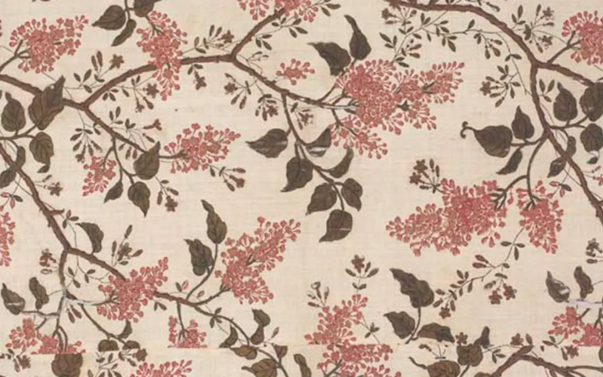 Floral fabric pattern with brown branches and leaves, and pink flower clusters on a beige background.