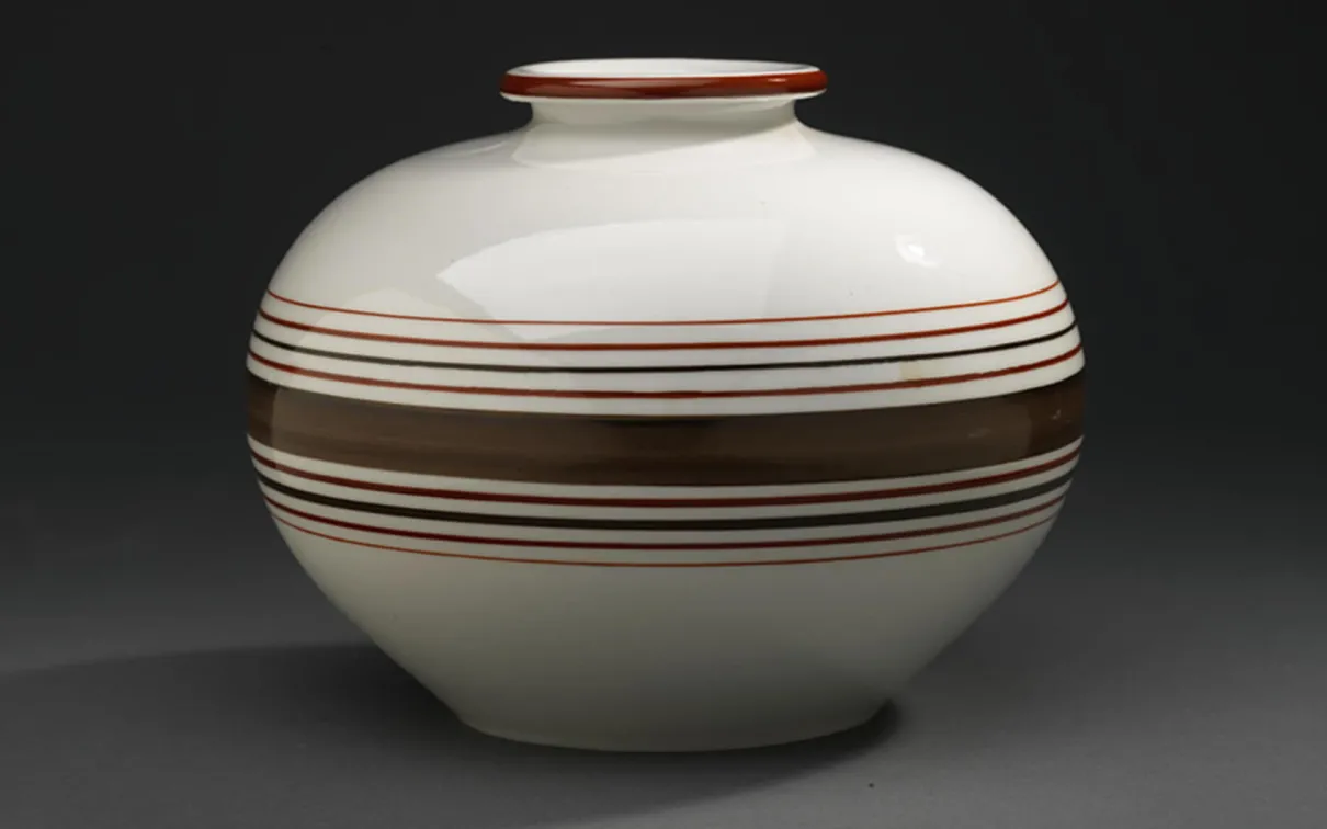 Un vase en porcelaine avec des rayures brunes.
