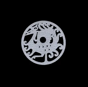 Circular jade disc carved with an abstract dragon and cloud motifs on a black background.