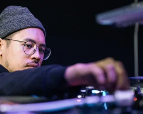 Image of DJ T.lo spinning on turntable