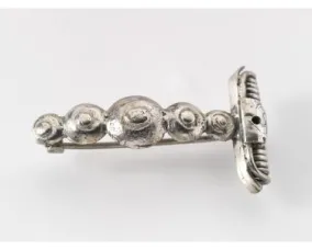 A silver brooch with spiral decorations