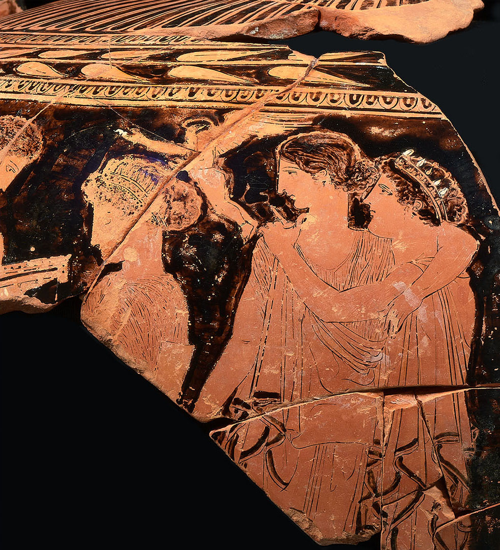 Ancient Greek terracotta pottery fragment showing two figures in profile with decorative patterns above.